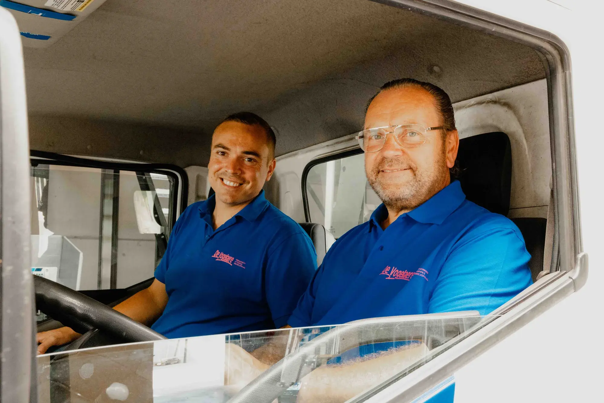 Twee collega's in de cabine van een verhuiswagen